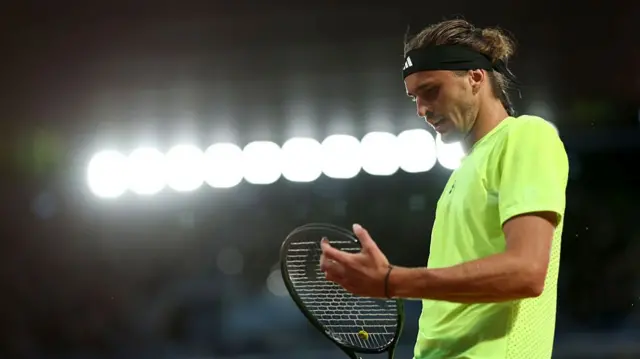 Alexander Zverev inspects his racquet