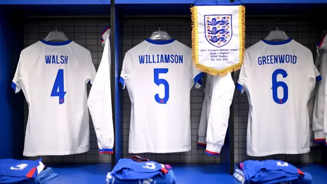 A general view as the match pennant is displayed alongside the match shirts of Keira Walsh, Leah Williamson and Alex Greenwood, inside of the England dressing room p