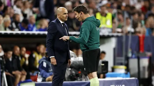 Roberto Martinez speaks to the fourth official