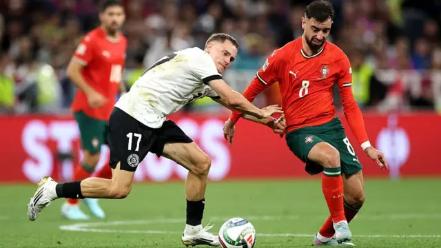 Florian Wirtz and Bruno Fernandes tussle