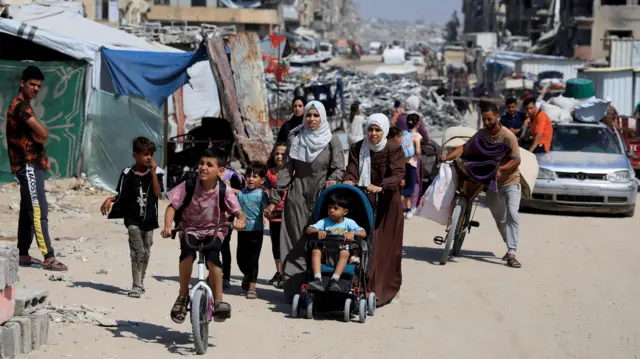 Palestinians carry their belongings as they flee their homes