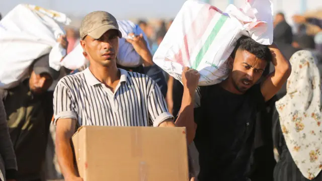 Palestinians carry aid supplies they received from the US-backed Gaza Humanitarian Foundation