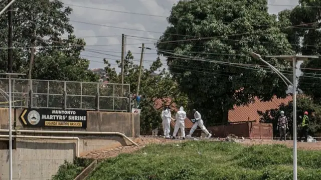 Ugandan Police officers in personal protective equipment operate near the Munyonyo Martyrs Shrine in Kampala on 3 June