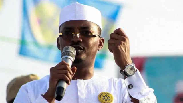 Mahamat Déby holds a microphone in his hand while he speaks.