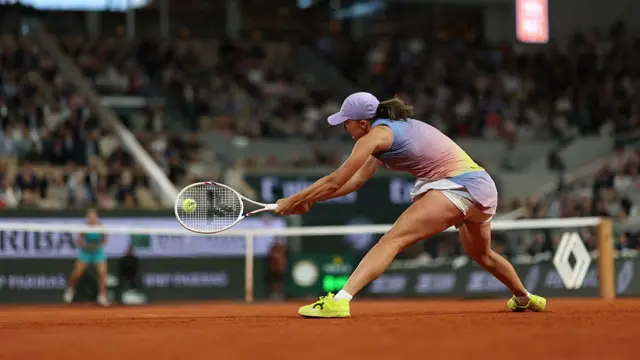 Iga Swiatek plays a backhand against Aryna Sabalenka