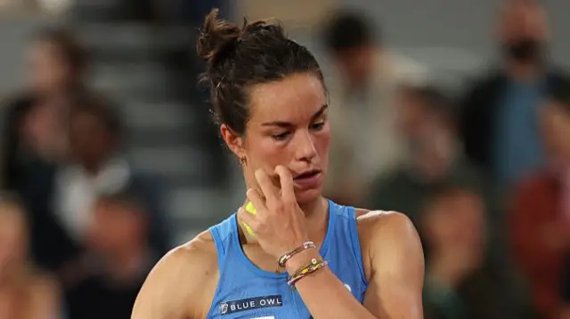 Lois Boisson scratches her face