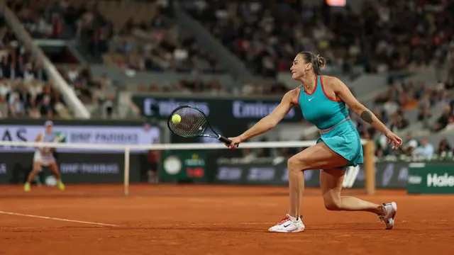 Aryna Sabalenka plays a backhand against Iga Swiatek