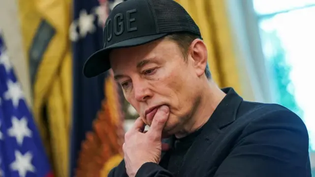 Elon Musk reacts during a press conference