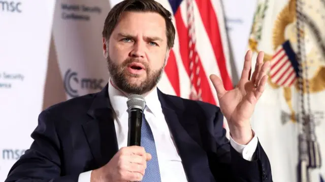 Vance speaking into a microphone at the Munich Security Conference