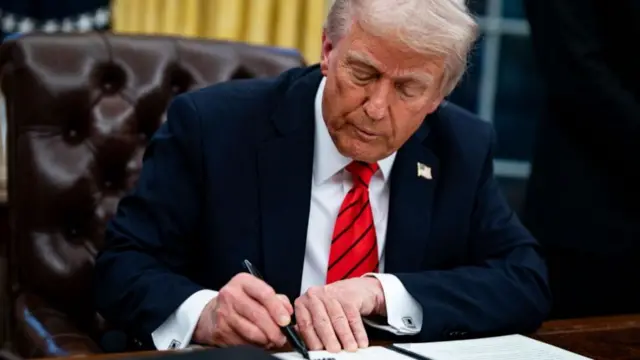 Trump signing an executive order in the Oval Office