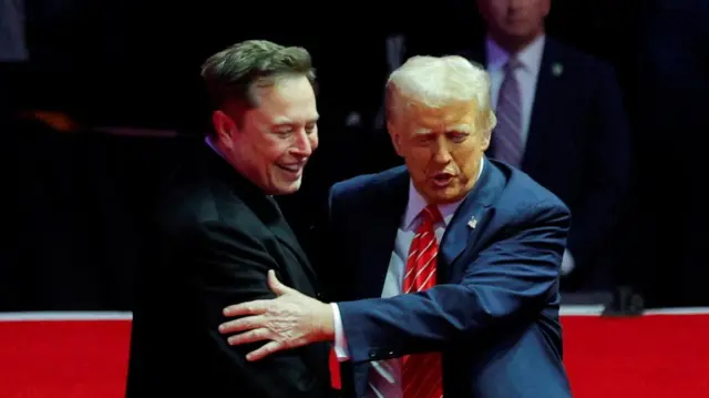 Trump and Musk embrace on a rally podium.