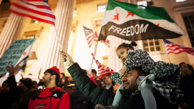 Protesters wave American flags and a Yemeni flag in front of Brooklyn Borough Hall during protest