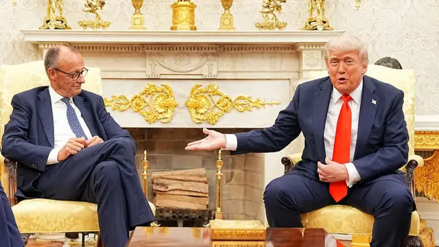 Trump gestures with his hand while sitting on a yellow chair. Sitting beside him in another chair is Merz.