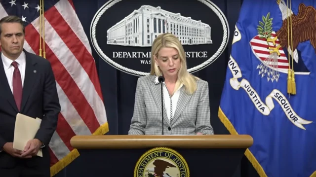 Pam Bondi speaking at the Department of Justice, with Todd Blanche to her right