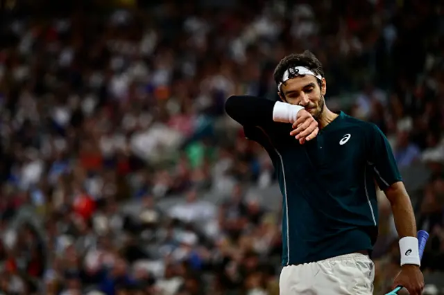 Italy's Lorenzo Musetti wipes his face