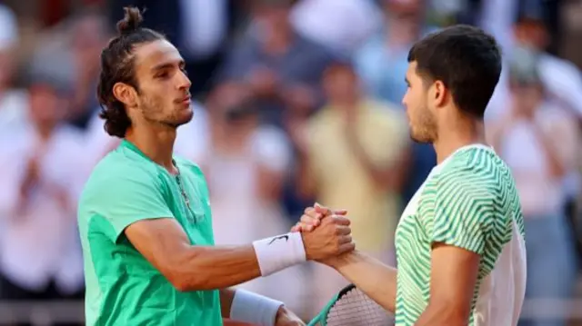 Carlos Alcaraz of Spain shakes hands with Lorenzo Musetti