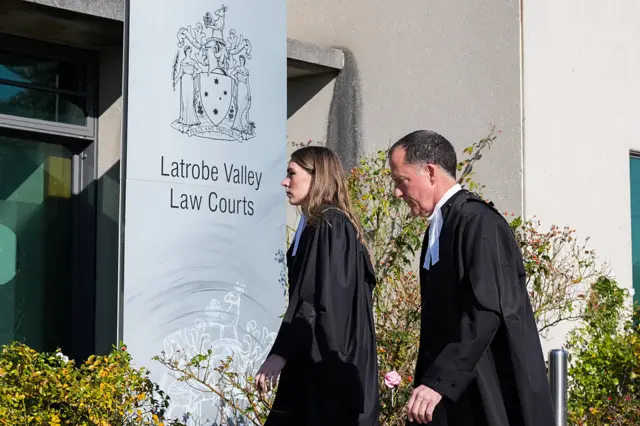 Two people walk past Latrobe Valley Law Courts sign