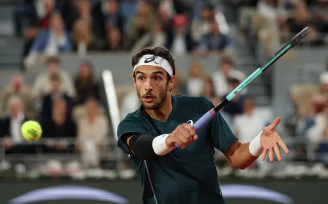 Lorenzo Musetti of Italy plays a backhand against Carlos Alcaraz