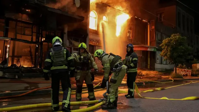 Firefighters work at the site of a Russian drone attack in Kyiv
