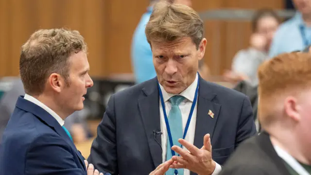 Richard Tice talks to another man at the count