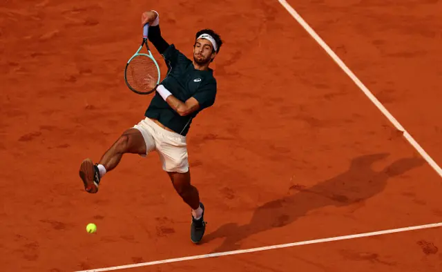 Lorenzo Musetti of Italy plays a smash against Frances Tiafoe