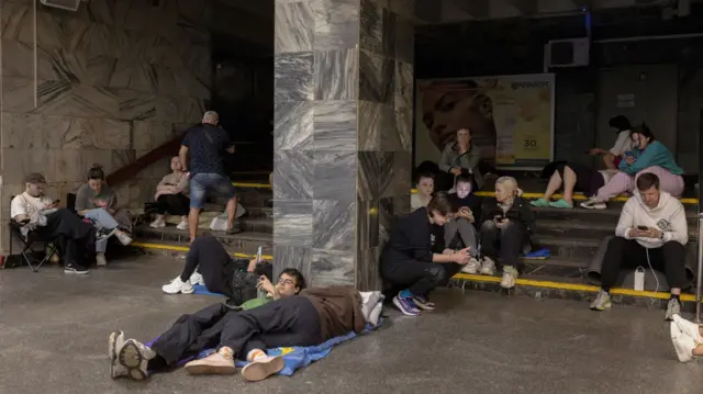 Pople sitting at a metro station in Kyuv during a Russian drone strike