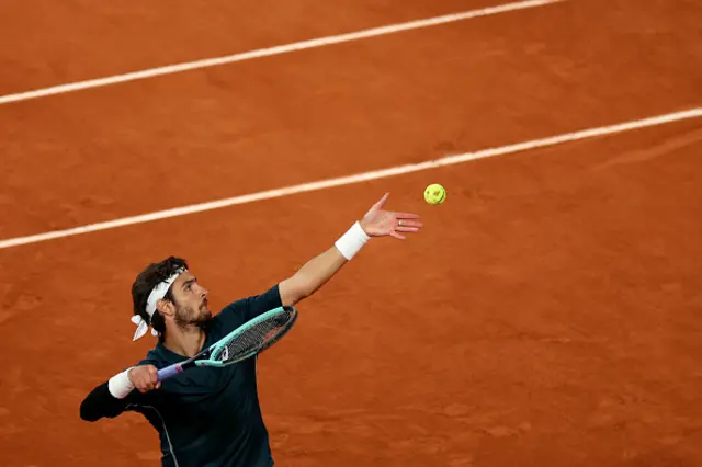 Italy's Lorenzo Musetti serves to Spain's Carlos Alcaraz