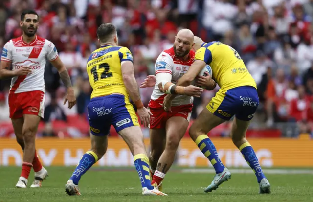 Hull Kingston Rovers' Sam Luckley (centre) is tackled by Warrington Wolves' James Harrison