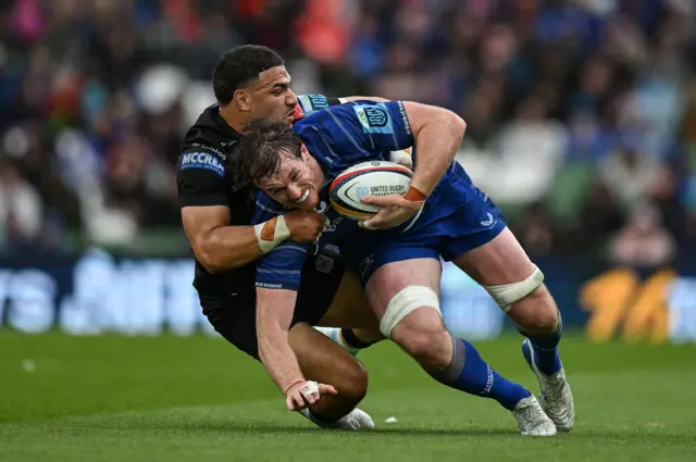 Ryan Baird of Leinster is tackled by Sione Tuipulotu of Glasgow Warriors