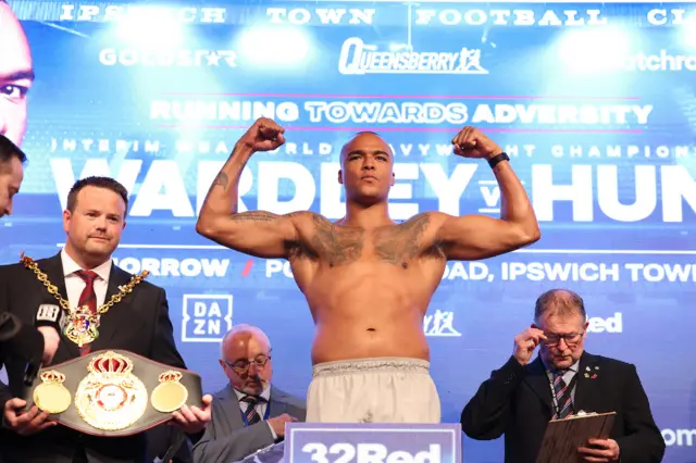 Fabio Wardley flexing his biceps on the scales