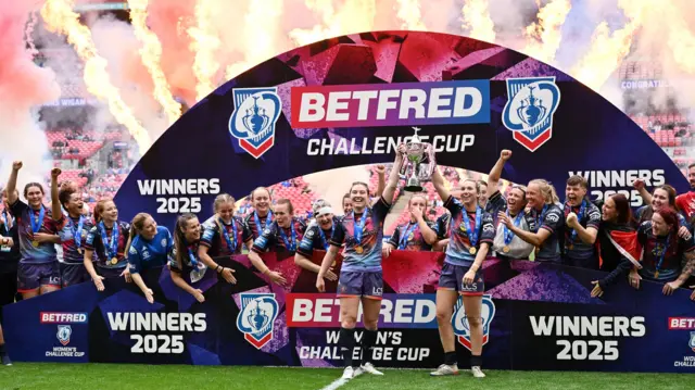 Wigan Warriors on the pitch with the Women's Challenge Cup trophy