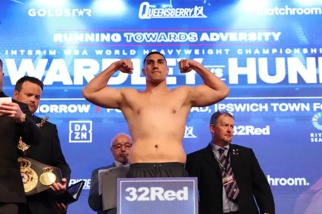 Justis Huni flexing his biceps on the scales