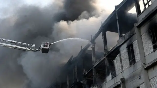 A firefighter extinguishes a fire at a civilian plant following Russian powerful attacks on
