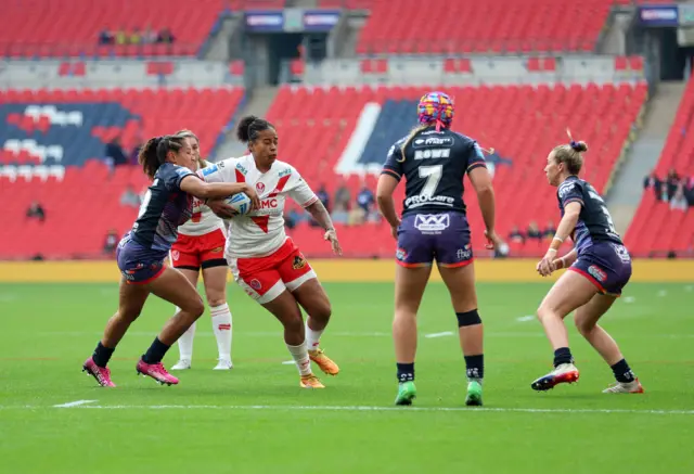 St Helens' Channy Crowl and Wigan Warriors' Shaniah Power battle for the ball
