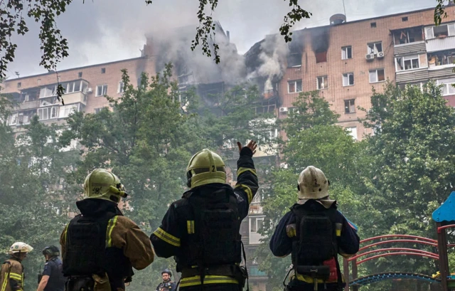 Rescuers work at the site of a drone strike in Kharkiv