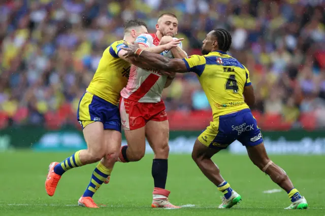 Hull KR's Mikey Lewis is held by Warrington defenders