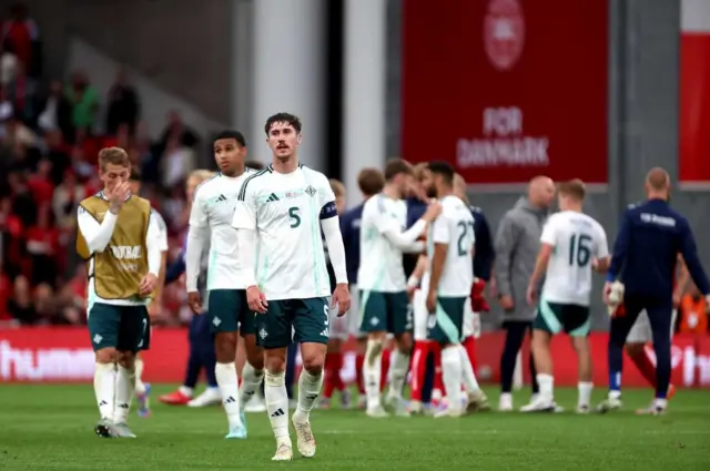 Trai Hume and the Northern Ireland players dejected at full time