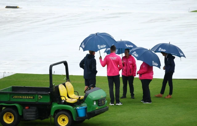 Umpires on the pitch as rain delays play Action