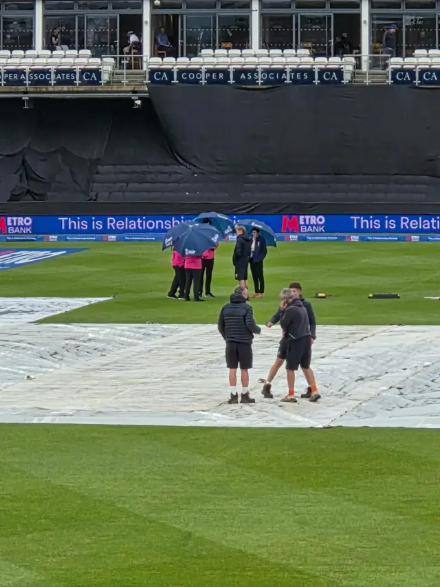 Groundman on the wicket covers
