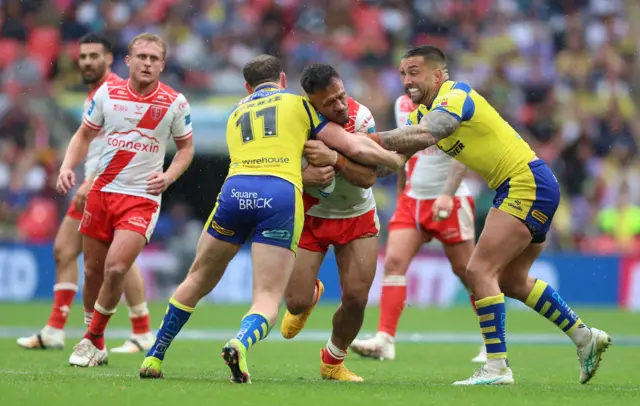 Hull Kingston Rovers' Sauaso Sue (centre) is tackled by Warrington Wolves' Ben Currie (left) and Warrington Wolves' Paul Vaughan