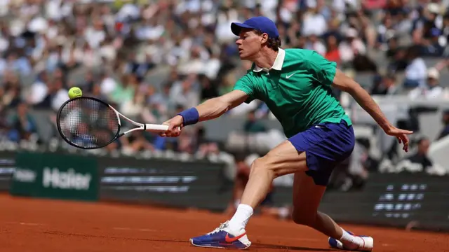 Jannik Sinner plays a backhand return