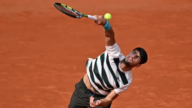 Carlos Alcaraz serves