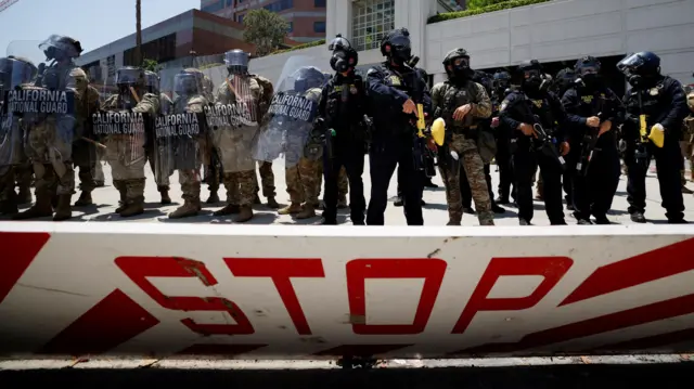 A stop sign in front of law enforcement