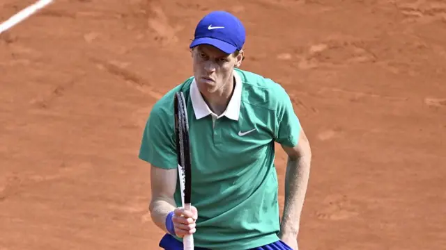 Jannik Sinner shakes his racquet