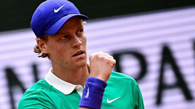 Jannik Sinner reacts after winning a game