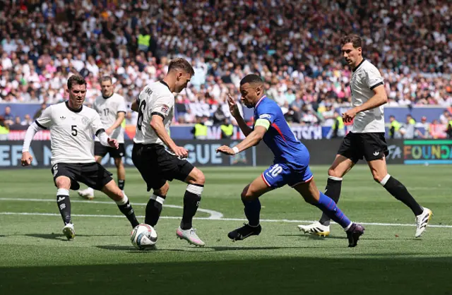 Kylian Mbappe of France runs with the ball past Pascal Gross, Joshua Kimmich and Leon Goretzka