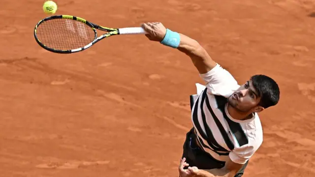Carlos Alcaraz serves