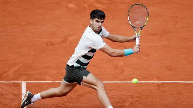 Carlos Alcaraz returns a backhand