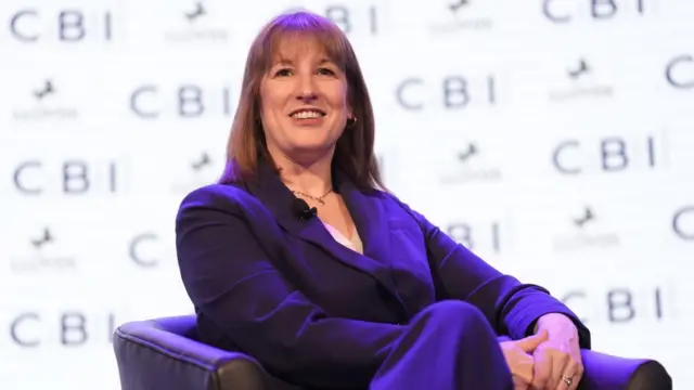 Chancellor Rachel Reeves sat on a chair, smiling.