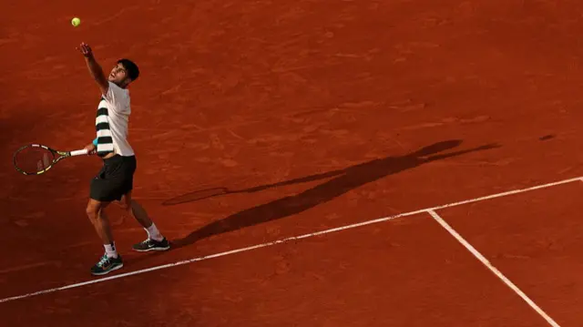 Carlos Alcaraz serves
